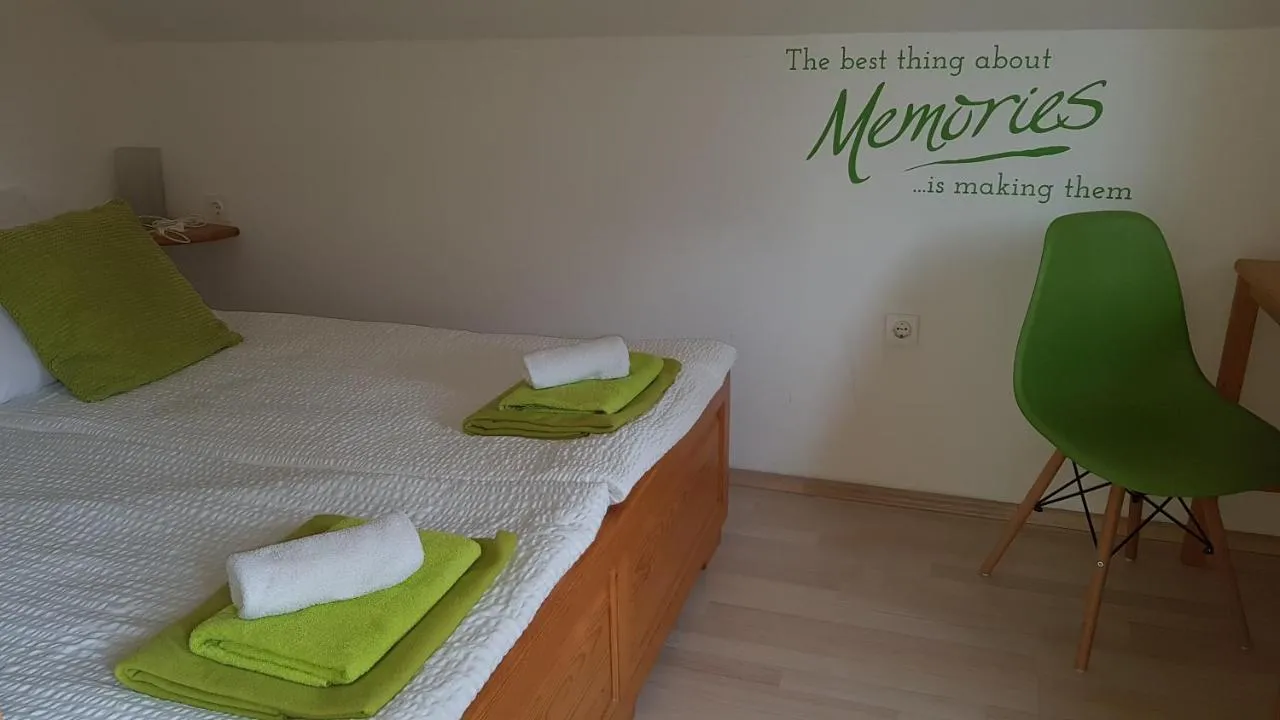 Spalnica z zakonsko posteljo in zelenim stolom