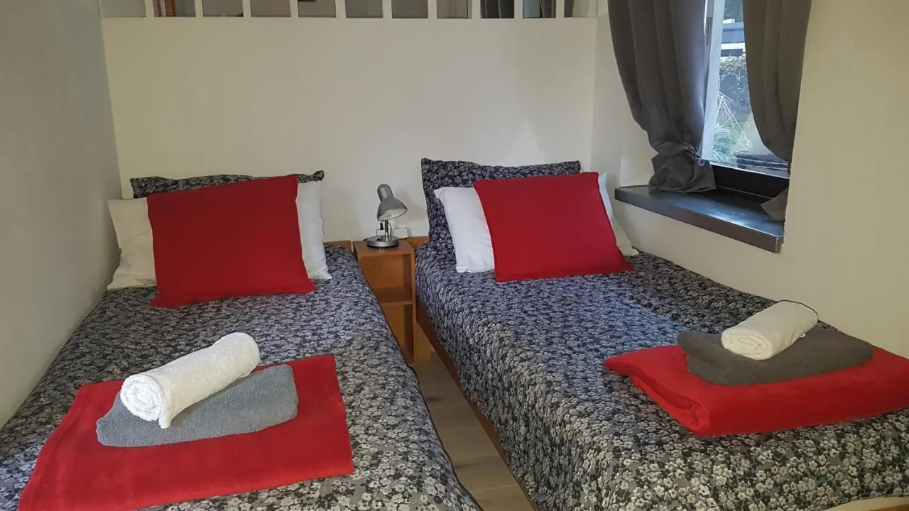 Spalnica z dvema ležiščema in rdečimi blazinami