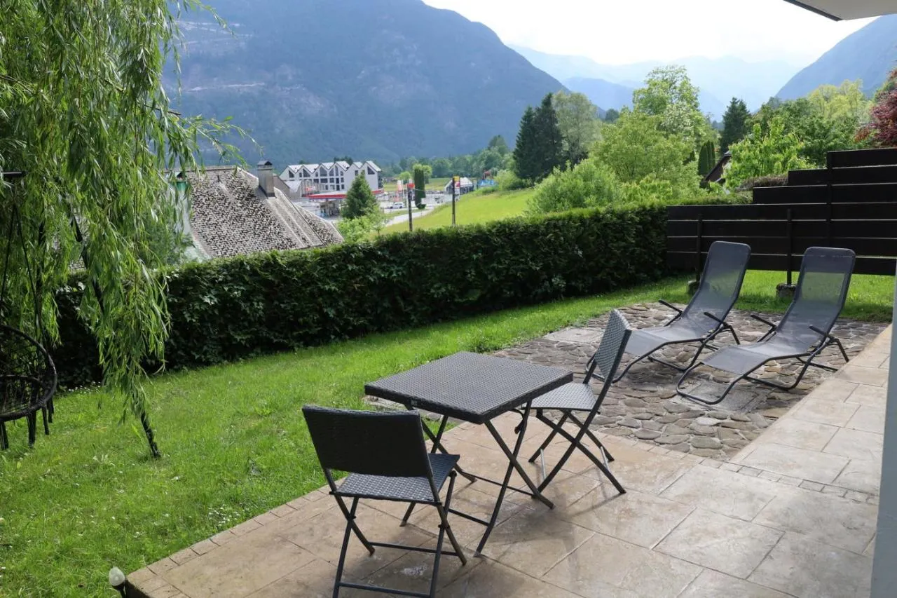 Terasa in vrt apartmaja 3 z ležalniki, žalujočo vrbo in razgledom na gore